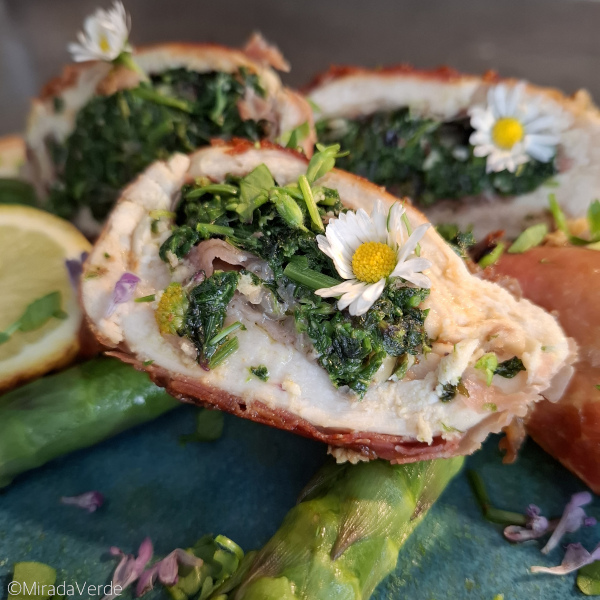 Huhn mit Wildkräuterfülle im Prosciuttomantel auf grünem Spargel