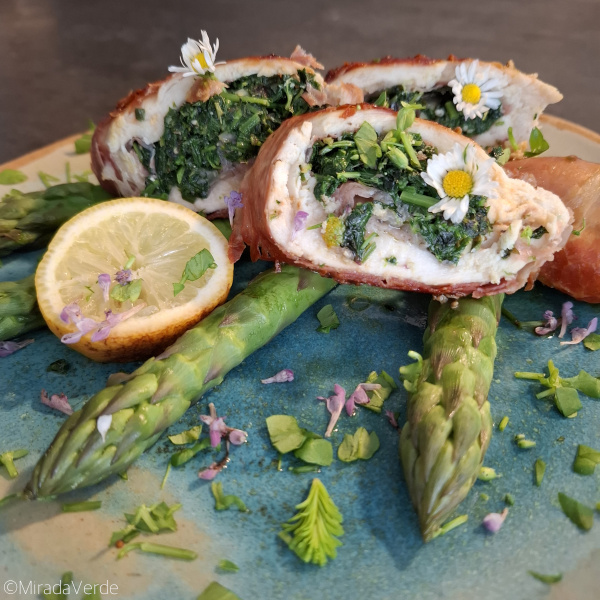 Huhn mit Wildkräuterfülle im Prosciuttomantel auf grünem Spargel