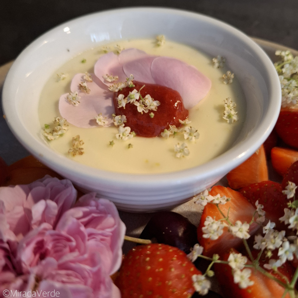 Holunderblütenpudding mit Rosen- und Holunderblüten und Erdbeermus garniert