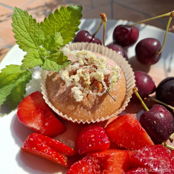 Holunderblütenmuffin mit kandierter Holunderblüte auf Erdbeeren und Kirschen, Zitronenmelisse