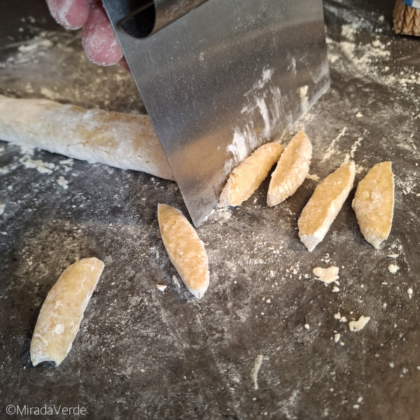 Schupfnudeln von der Kartoffelteigrolle abstechen